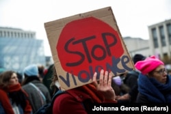 Seorang demonstran memegang plakat saat protes terhadap ketidaksetaraan, kekerasan, KDRT dan pelecehan seksual terhadap perempuan di Brussels, Belgia, 28 November 2021. (Foto: REUTERS/Johanna Geron)