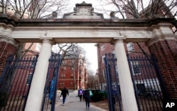 Orang-orang berjalan melewati gerbang menuju Harvard Yard, di Universitas Harvard di Cambridge, 13 Desember 2018. (Foto: AP)