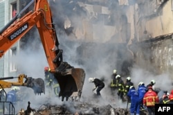 Tim penyelamat bekerja di puing-puing bangunan tempat tinggal yang rusak di Uman, di Oblast Cherkasy, Ukraina tengah, pada 28 April 2023, setelah serangan rudal Rusia menargetkan beberapa kota di Ukraina dalam semalam. (Foto: AFP)