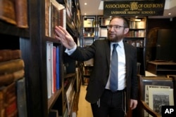 Rabi Nicky Liss melihat barang-barang koleksi milik Profesor David Latchman berupa memorabilia yang berkaitan dengan sejarah Yahudi Inggris, di London, Jumat, 28 April 2023. (AP/Kirsty Wigglesworth)