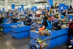 Sejumlah kasir sedang menghitung pembelian pelanggan di Walmart Supercenter di North Bergen, New Jersey, 9 Februari 2023. (Foto: Eduardo Munoz Alvarez/AP)