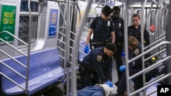 Sejumlah petugas kepolisian New Yoprk tampak berusaha melakukan CPR terhadap Jordan Neely yang tengah sekarat di sebuah gerbong kereta bawah tanah di New York, pada 1 Mei 2023. (Foto: Paul Martinka via AP)
