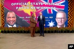Perdana Menteri Australia Anthony Albanese, kiri, dan Perdana Menteri Papua Nugini James Marape berjabat tangan di luar gedung parlemen di Port Moresby, Papua Nugini, Kamis, 12 Januari 2023. (Foto: via AP)