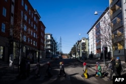 Anak-anak PAUD "I Ur och Skur" di Jarvastaden, Solna, Swedia, menyeberang jalan dalam perjalanan kembali ke prasekolah setelah berada di alam, pada 1 Maret 2023. (Jonathan NACKSTRAND/AFP)