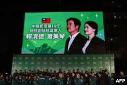 Foto presiden terpilih Taiwan Lai Ching-te dan pasangannya Hsiao Bi-khim di luar markas Partai Progresif Demokrat (DPP) di Taipei pada 13 Januari 2024. (Foto: AFP)
