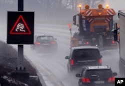 Sebuah truk penebar garam melaju di jalan raya saat hujan mulai turun dan suhu rendah di Frankfurt, Jerman, Rabu, 17 Januari 2024. (AP/Michael Probst)