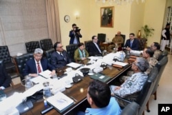 Dalam foto yang dirilis oleh kantor Perdana Menteri Pakistan, PM sementara Pakistan Anwaar-ul-Haq Kakar, kanan tengah, memimpin pertemuan Komite Keamanan Nasional di Islamabad, Jumat 19 Januari 2024.