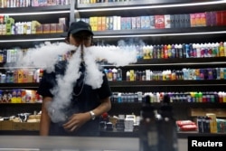 Seorang karyawan toko rokok elektrik di Jakarta, 23 Oktober 2020. (Foto: REUTERS/Ajeng Dinar Ulfiana)