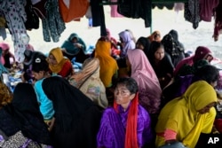 Perempuan etnis Rohingya berlindung di bawah tenda dekat pantai tempat mereka mendarat pada 10 Desember di Pidie, Aceh, 16 Desember 2023. (Foto: AP)