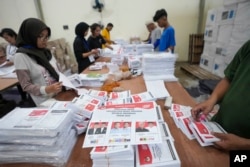 Para pekerja melipat surat suara untuk pemilu presiden saat persiapan distribusi logistik pemilu di Tangerang, 10 Januari 2024. (Foto: AP)